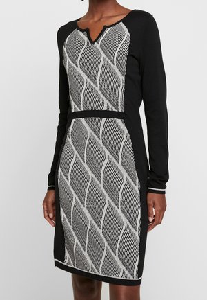 Black long-sleeve dress with white and black wavy diagonal striped pattern on front and slightly notched neckline.