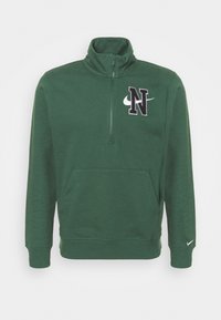 Zelená mikina na zip s vysokým límcem, obsahující přední kapsu, černé logo "N" a bílé logo Nike na rukávu.