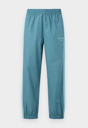 Pantalon de sport bleu clair avec taille et chevilles élastiques, bandes blanches sur les côtés, et logo New Balance sur le haut de la cuisse gauche.