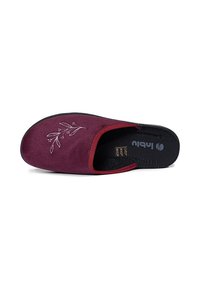 Burgundowe buty wsuwane z zamszową cholewką, haftowanymi kwiatowymi detalami, czarną wkładką i kontrastującymi czerwonymi wykończeniami. Płaska podeszwa o teksturowanym wykończeniu.
