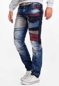 Denim broek met een patchworkontwerp in tinten blauw, grijs en rood. Inclusief verschillende textuurpanelen en een slim fit.