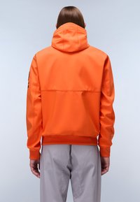 Giacca arancione con cappuccio, dal texture morbida e con una finitura leggermente riflettente. Presenta una vestibilità rilassata e un dettaglio di tasca posteriore con zip.