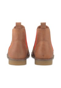 Paire de bottines en cuir marron avec des panneaux élastiques orange sur les côtés et des semelles en caoutchouc beige, vues de dos sur fond blanc.