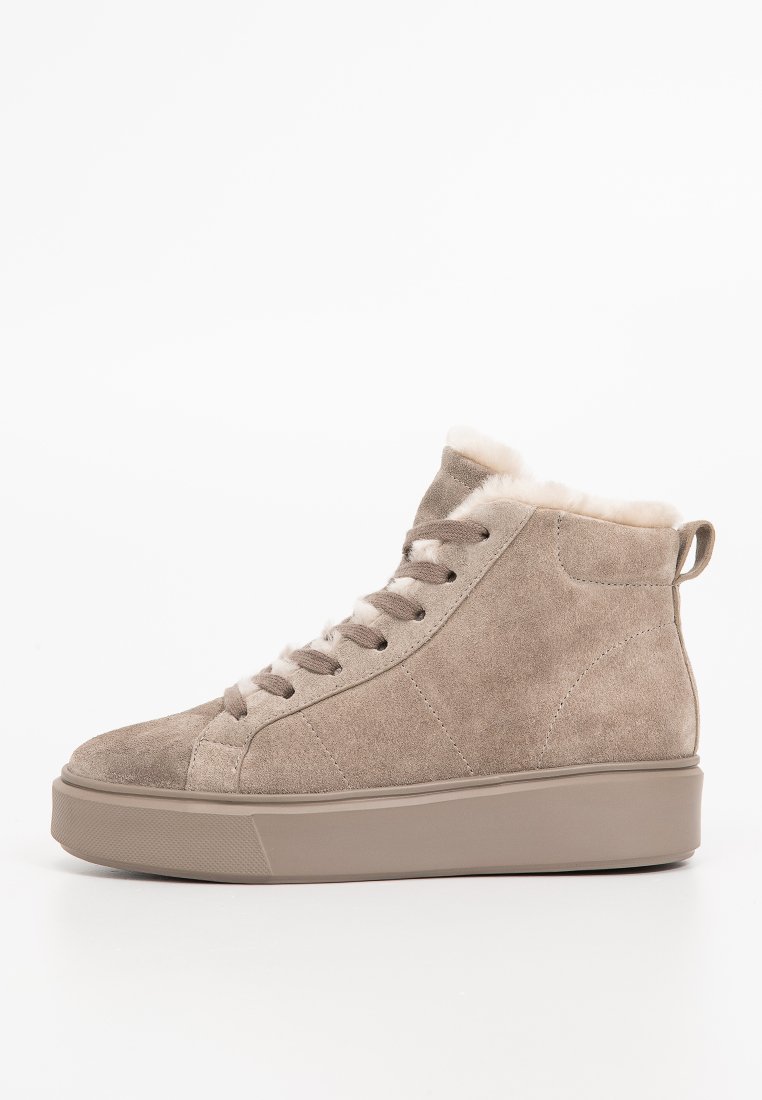 Beżowe sneakersy na wysokiej podeszwie z zamszu, z beżowymi sznurówkami, grubą gumową wkładką, miękkim futerkiem widocznym przy kostce i pętelką z tyłu.
