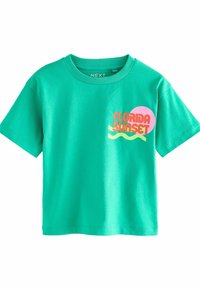 Grön t-shirt med kort ärm i bomull. Har en grafik med "Florida Sunset" i röd och rosa med vågiga accenter.
