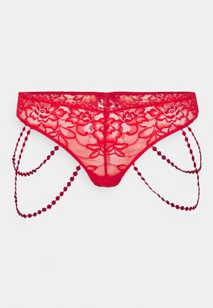 Rote Spitzenstringtanga mit floralem Muster, gewellten Kanten und dekorativen Kettenakzenten. Netzstoff mit dehnbaren Trägern an den Seiten.