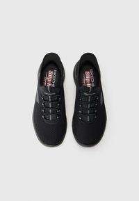 Pair of black Skechers slip-on sneakers with elastic laces and slip-resistant soles, shown from above on a white background.