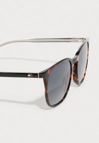 Καφέ χελώνα γυαλιά ηλίου με σκούρους φακούς gradient, με ασημένιες μεταλλικές λεπτομέρειες και λογότυπο στο βραχίονα. Ρετρό σχήμα γατίσιας ματιάς.