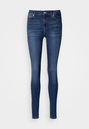 Jeansi skinny din denim albastru închis, cu talie medie, design cu cinci buzunare și ușoare zone de uzură pe față și pe spate.