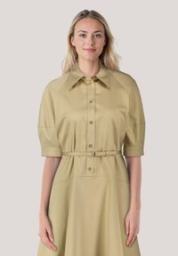 Khaki Hemdkleid mit kurzen, puffigen Ärmeln; taillierter Bund; glattes Gewebe; strukturierter Kragen; knielanger Rock; dezenter Glanz.
