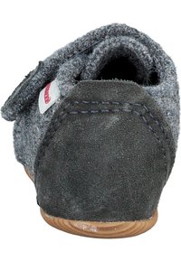 Chausson en feutre gris avec talon en daim foncé, accents cousus et forme arrondie. Dispose d'une bride Velcro pour un ajustement sécurisé. Semelle en bois.