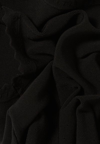 Tissu noir avec une surface texturée et nervurée, présentant des plis doux et fluides ainsi qu'un bord festonné. Adapté pour la conception de vêtements.