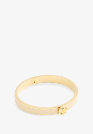 Armband aus goldfarbenem Metall mit glatter Oberfläche und rundem Verschluss, graviert mit der Aufschrift "COACH".