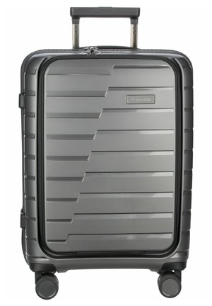 Valigia a mano rigida, grigia con superficie texturizzata caratterizzata da scanalature parallele, manico telescopico e quattro ruote girevoli per la mobilità.