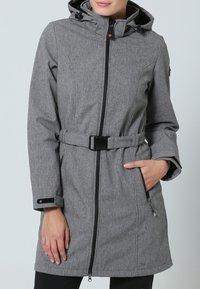 Veste à capuche grise avec taille ceinturée, fermeture éclair à l'avant et deux poches latérales. Le tissu présente un motif texturé ; la fermeture utilise des éléments en métal noir.