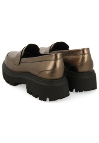 Zapatos de bronce metálico con una parte superior lisa, forma de punta rectangular y suelas de goma negra gruesa con dibujos profundos para una mejor tracción.