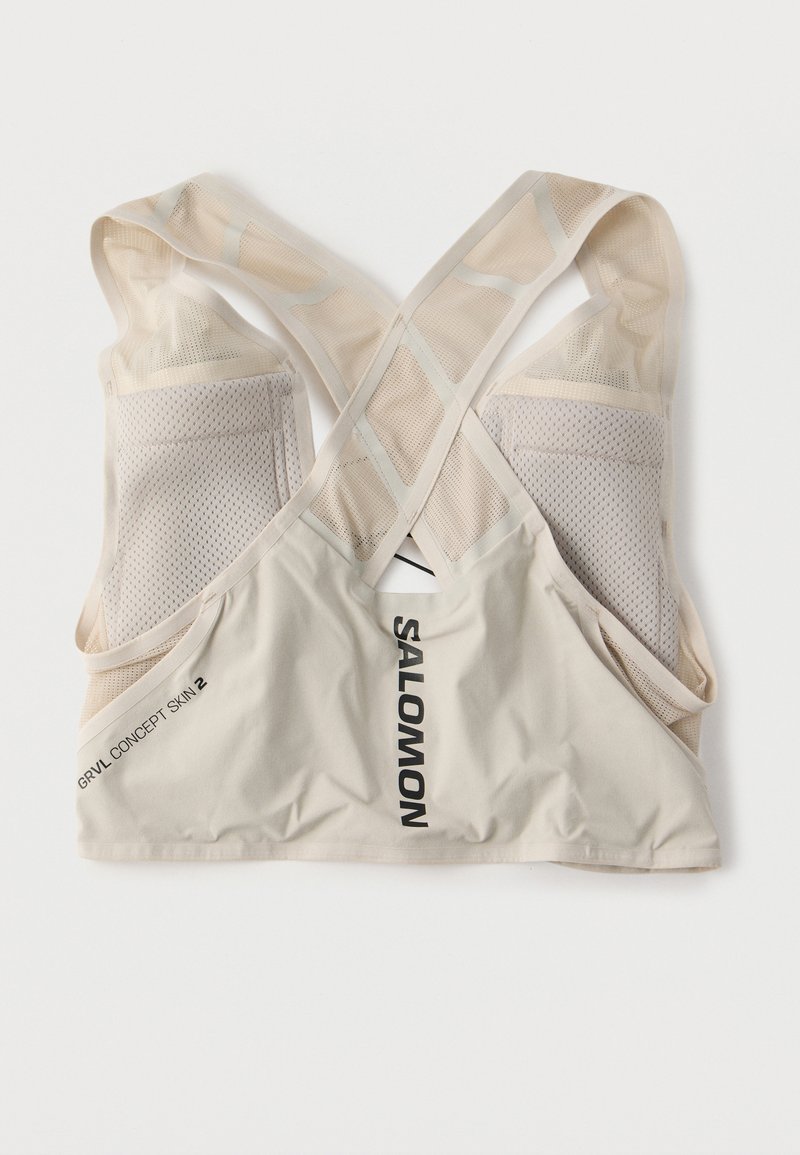 Gilet de course beige Salomon GRVL CONCEPT SKIN 2 avec bretelles en maille et poches arrière, posé à plat sur un fond blanc.