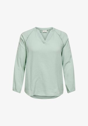 Hellgrün langärmlige Bluse aus strukturiertem Stoff mit V-Ausschnitt und gesteppten Akzenten entlang der Schultern. Abgerundeter Saum.