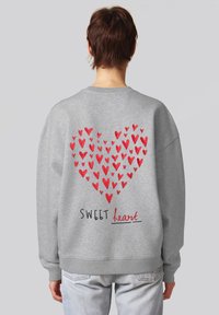 Sweatshirt grigio con motivo a cuori rossi composto da cuori più piccoli e la scritta "SWEET heart" in nero e rosso sul retro. Texture morbida.
