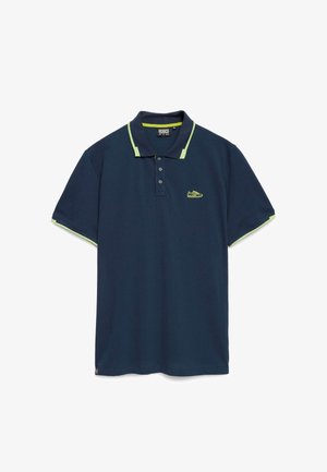 Tamno plavi polo majica napravljena od pamuka s zelenim detaljima na ovratniku i rukavima. Ima tri gumba i mali logo.
