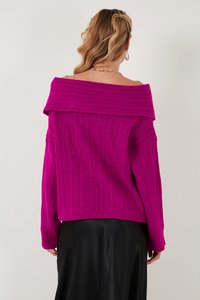 Rózsaszín, off-shoulder pulóver bordás textúrával, hosszú ujjakkal és laza fazonnal, fekete selyem szoknyával párosítva.