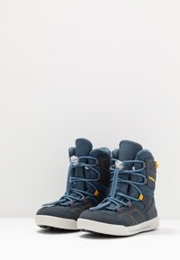 Stivali da neve blu e grigi con tessuto testurizzato e dettagli in pelle liscia. Presentano lacci elastici e una suola in gomma per una buona aderenza.