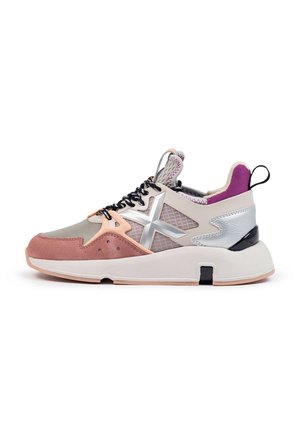 Zapatilla moderna con ante rosa, malla beige, detalles metálicos plateados, cordones negros y blancos, forro interior morado y suela blanca gruesa.