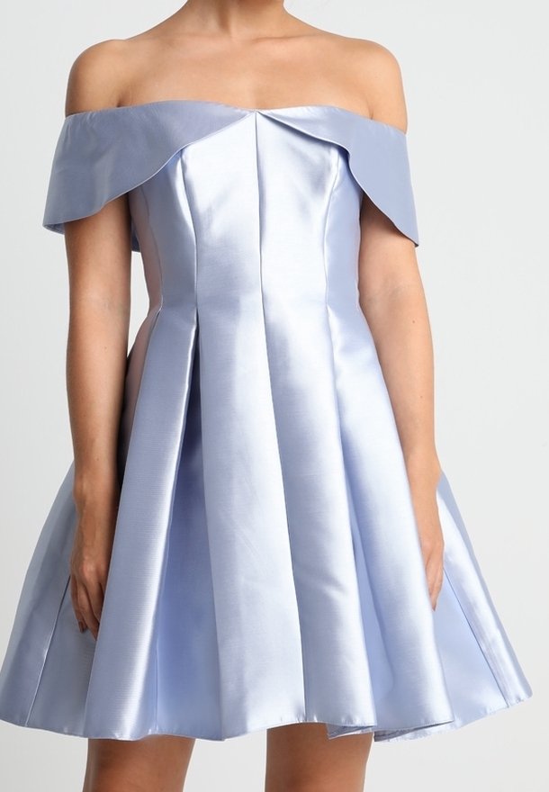 Žena v světle modrých saténových šatech s odhalenými rameny, s upnutým korzetem a rozšířenou sukní, na jednobarevném pozadí.