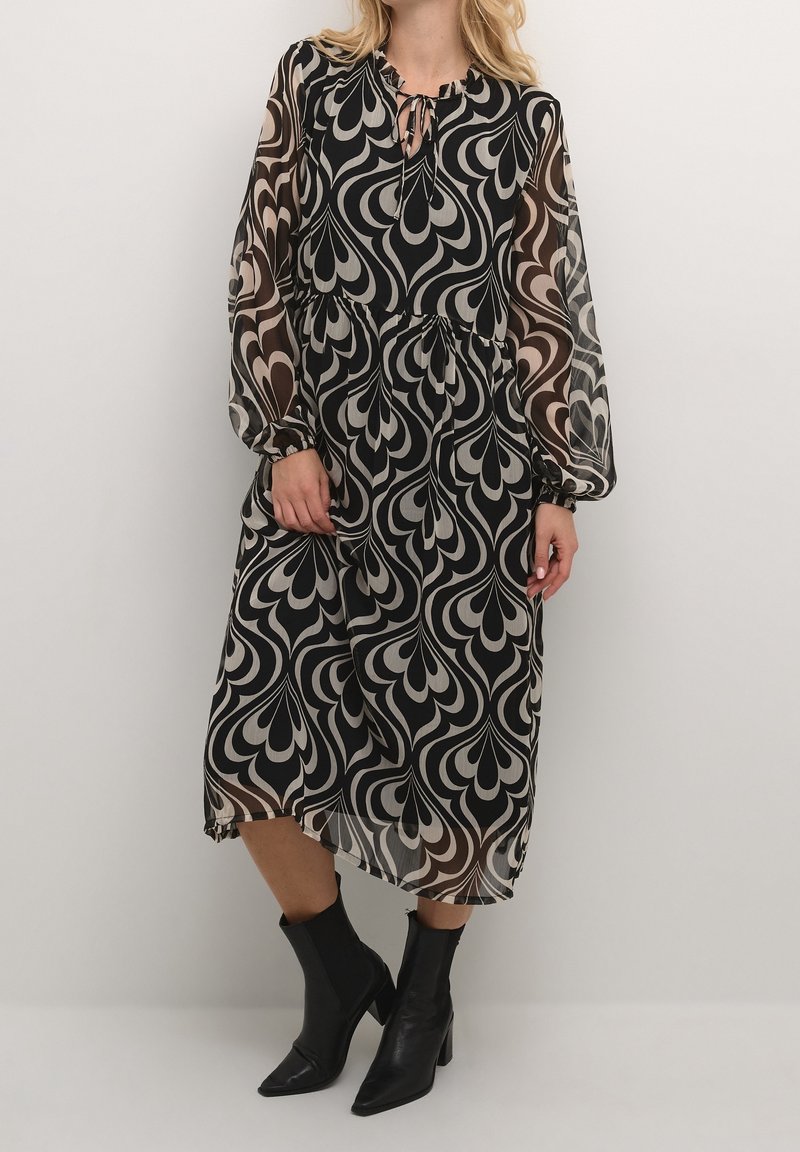 Robe midi noire et beige à motifs, avec manches longues en voile transparent et encolure à ouverture en goutte d'eau. Le tissu a une texture fluide ; présente une taille froncée.