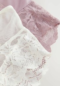 Set aus Spitzentüchern in sanftem Weiß und Lavendel. Verfügt über kunstvolle Blumenmuster und gewellte Kanten, die zarte Texturen betonen.