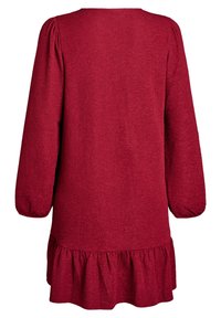 Sarkans kleita ar garām pūkām, teksturēta auduma, apaļu kakla izgriezumu un platu volānu apakšmalā. Vienkārša, brīva silueta.