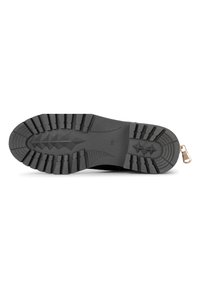 Suela de zapato de goma negra con un patrón de relieve texturizado, que presenta surcos profundos y un acento metálico en el talón para agarre y durabilidad.