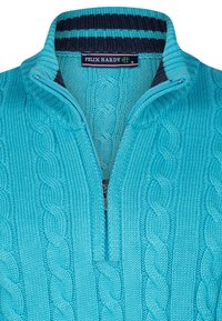 Türkis gestrickter Pullover mit einem Reißverschlusskragen, der ein Kabelstrickmuster aufweist. Der Innenkragen hat marineblaue und türkisfarbene Streifen.