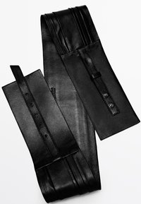 Czarny szeroki skórzany pasek w talii z przeszyciami i regulowanym zapięciem na zatrzask na białym tle.