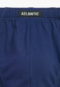 Granatowe bawełniane bokserki z elastycznym paskiem, z czarną etykietą z napisem "ATLANTIC" na białym tle. Gładka tekstura.