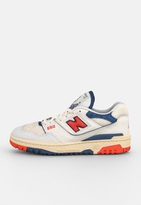 Basket blanc et marine avec un logo rouge, en mesh et cuir, col rembourré, languette texturée, et semelle en caoutchouc multicolore.