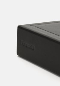 Black Polaroid photo album with a textured surface, featuring a debossed logo, sleek rectangular shape, and subtle geometric accents.