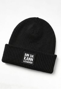 Black knitted beanie with a ribbed texture and a folded cuff, featuring a white rectangular patch that reads "BIN DA KANN LOSGEHEN."