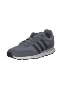 Zapatillas deportivas grises que combinan materiales lisos y texturizados, con tres franjas negras a un lado y una entresuela blanca.