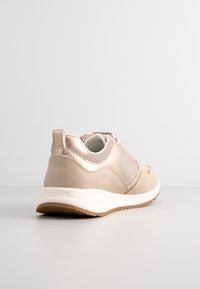 Sneaker beige con pannelli in suede e mesh, punta rotonda, colletto imbottito e suola in gomma bianca. Presenta una linguetta sul retro.