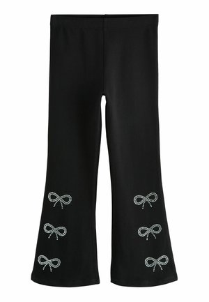Czarne legginsy dzwonowate wykonane z elastycznego materiału, ozdobione akcentami z cyrkonii w wzór kokardy na dolnej części nóg.