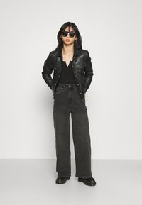 ONLY Petite ONLINC HOPEEX HI WIDE LEG REAPET - Calças de ganga de corte relaxado - black denim