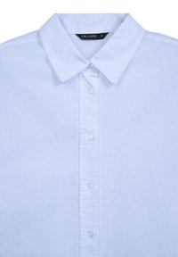 Camicia bianca con colletto a punta e etichetta del marchio visibile etichettata "CALLIOPE" nella taglia piccola.