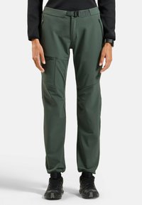 Grüne technische Hose mit Slim-Fit, ausgestattet mit Reißverschlusstaschen, einem Gürtel und verstärkten Kniefeldern. Hergestellt aus strapazierfähigem, leichtem Material.