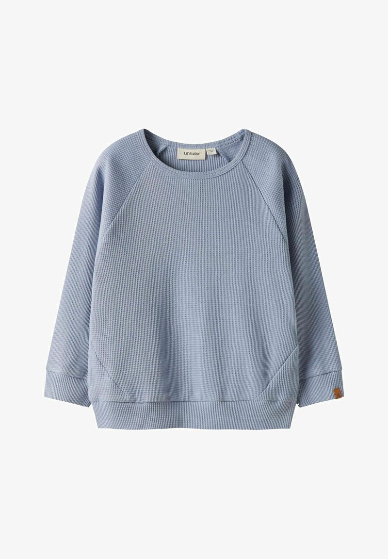 Pull-over bleu clair en maille gaufrée à manches longues avec col ras du cou, manches raglan, et petite étiquette de marque sur le poignet gauche.