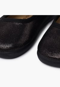 Scarpe di stoffa nere con una finitura tessurizzata e scintillante, punta arrotondata, suola nera flessibile e bordino elastico.