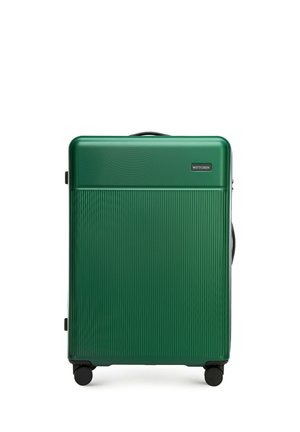 Green hardshell suitcase with horizontal ribbed texture, black accents, top handle, and four rolling wheels for mobility.