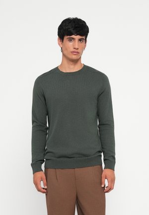 Green long-sleeve sweater made of textured fabric, featuring a crew neck and ribbed cuffs. Pairing with brown tailored trousers.