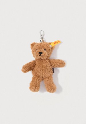 Brown plush teddy bear keychain with a soft, furry texture, stitched facial features, and a yellow tag with a logo. Silver clasp attachment.