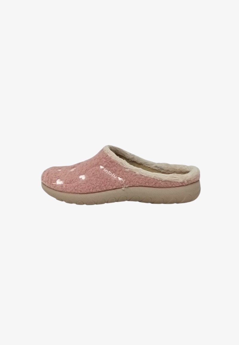 Pantofole in pile rosa senza lacci con suola beige e motivi a cuore bianchi, dotate di rivestimento morbido attorno all'apertura.